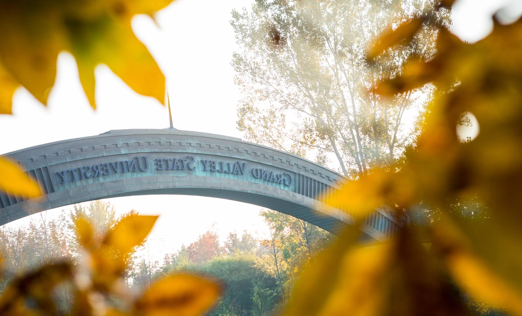 GVSU Entrance Arch in the early morning with fall leaves around it